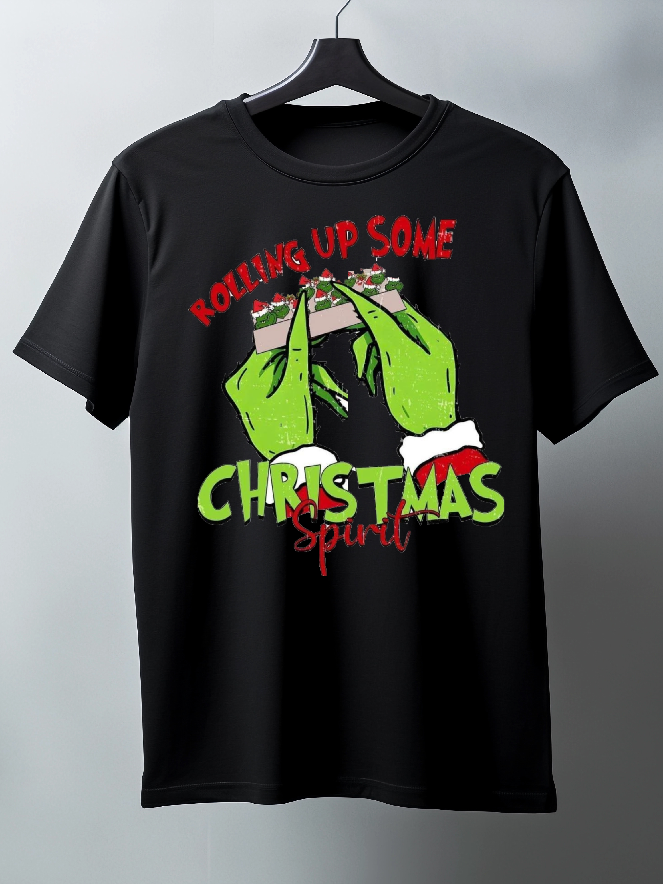Black t-shirt with green hands and text on a hanger against a gray background